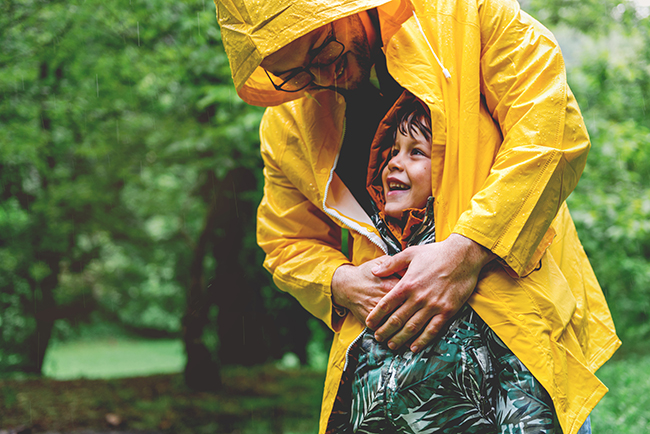 Father and young son having fun in the rain